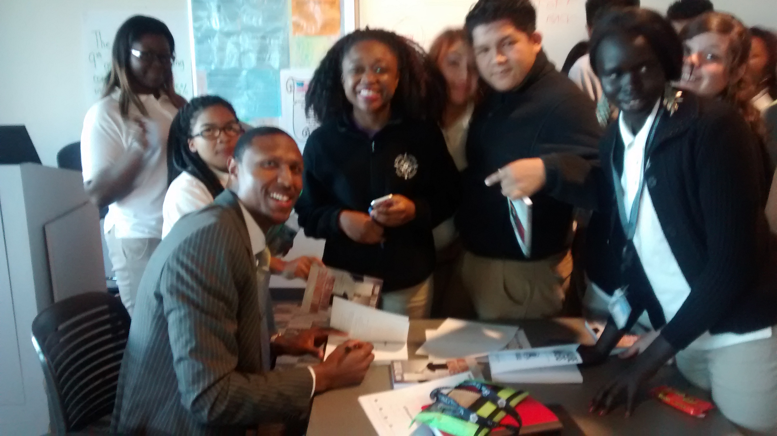 Sadiq signing books for the Honors Students at Digital Harbor